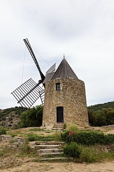 Old, historic windmill in Grimaud with the Massif des Maures in France in spring, Côte d'Azur