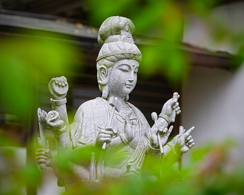 Zen Guanyin Statue through Green Leaves