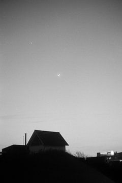 Wassende maan boven een duinhuis op Terschelling