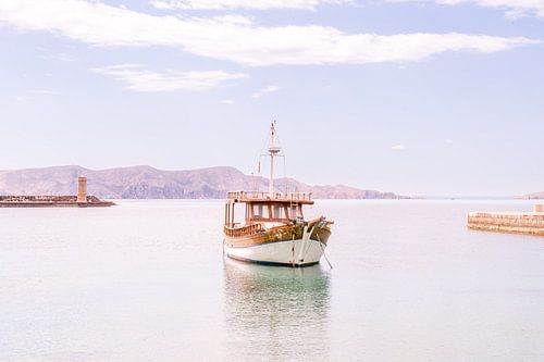 Dromerig zeezicht met vissersboot en bergen