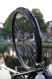 Fietswiel aan hek van gracht in Delft by Mariska van Vondelen