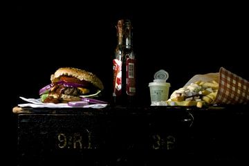 Foto van een stilleven met hamburger en friet. van Therese Brals