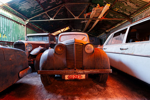 Oldtimer in verlassener Garage bei orangem Licht