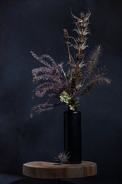 Stilleven (van uitgebloeide bloemen in een zwarte vaas) van Marjolijn van den Berg