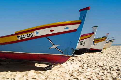 Brightly coloured fishing boats on the beach at Armacao da Pera in Portugal.