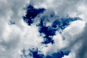 In de avond een donkerblauwe lucht met witte wolken