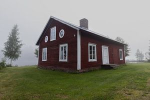 Schwedische rote Stuga in Nebel gehüllt