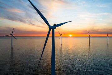 Windturbines in een offshore windpark tijdens zonsondergang