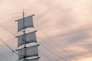 Alter Segelschiffmast und Segel bei Sonnenuntergang