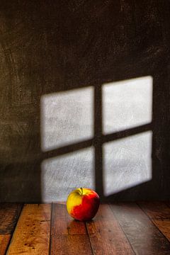 Appel geplaatst op een houten vlonder die belicht wordt door lichtinval binnenvallend door een  raam van René Ouderling