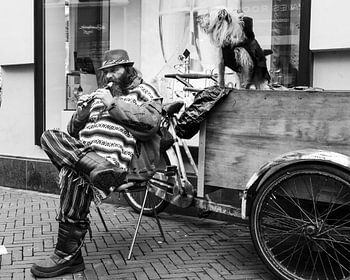 Man op straat speelt blokfluit.