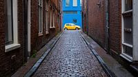 Yellow car against blue wall by Idema Media thumbnail