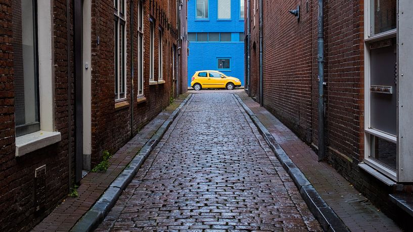 Yellow car against blue wall by Idema Media