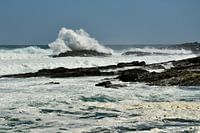 Plätschernde Welle und Schaum am felsigen Strand in Südafrika
