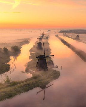 Sonnenaufgang in Kinderdijk - Windmühlen im Nebel und Spiegelung von Ewold Kooistra