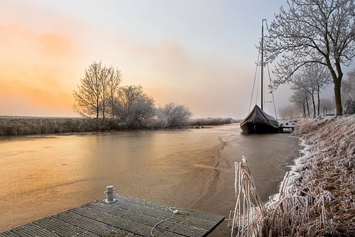Small sailboat, frozen in ice, Netherlands by Peter Bolman