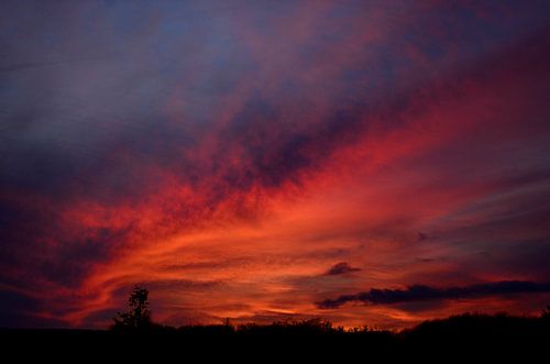 Dramatisch kleurende zonsondergang van Corinne Welp