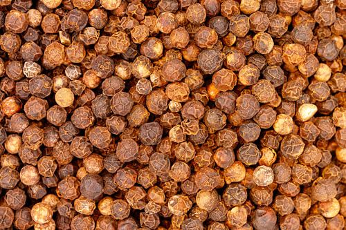 Black peppercorns creating spice food seasoning background texture