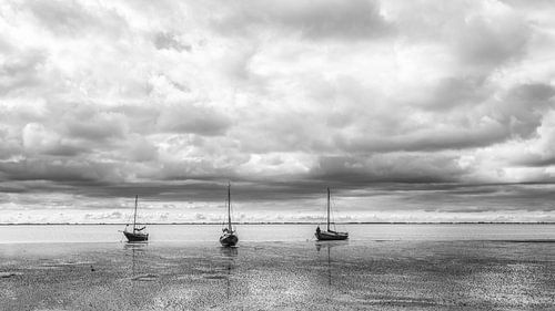 Boten op het drooggevallen Wad Ameland in zwart-wit