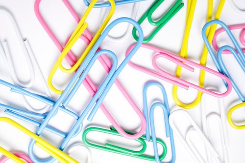 Kleurrijke paperclips op wit