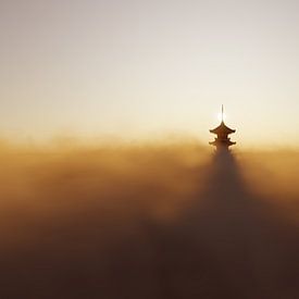 Een traditionele pagode die bij zonsondergang boven de wolken uitsteekt van Besa Art