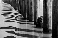 contrastrijke zwart wit foto met schaduw en strandpalen van Karijn | Fine art Natuur en Reis Fotografie thumbnail