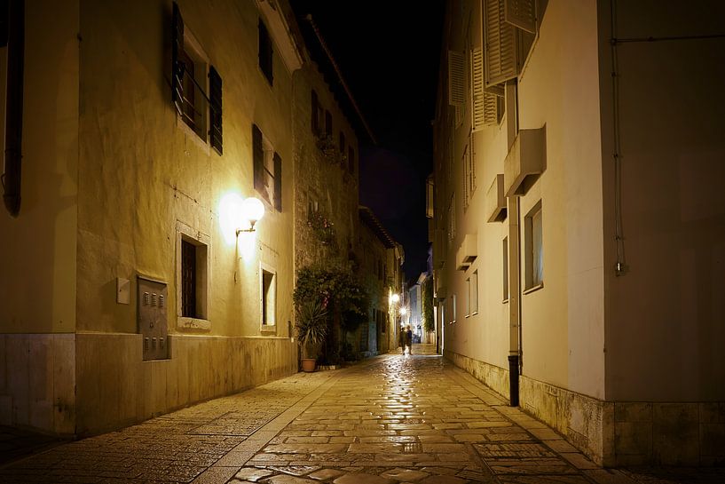 historical alley in the old town of Porec at night. by Heiko Kueverling