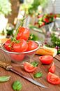 Fresh tomatoes lie in a colander on a wooden tray by Edith Albuschat thumbnail