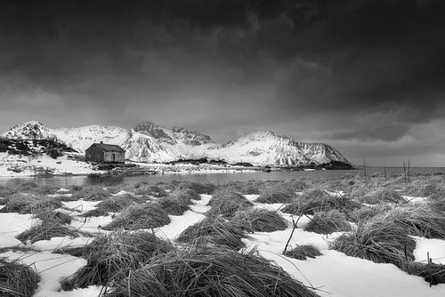 Houten huis in winterlandschap in Noorwegen in zwart-wit