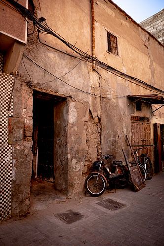 Old wall with mopeds in narrow street