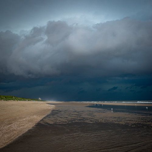 Donkerblauwe regenwolken aan het strand