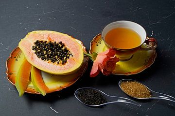 Schwarzer Tee mit geschnittener Papaya und Orangefarbiger Rose