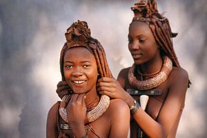 Namibia. Himba-Stamm. Mädchen arrangieren sich gegenseitig die Haare. von Frans Lemmens