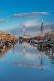 De Emmakade in de herfst met de schepen en wolken gereflecteerd. by Harrie Muis