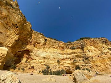 Een goudkleurige rotswand met blauwe hemel van Emma Van Leur