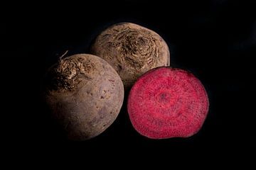 Three red beets on black background by Iris Koopmans