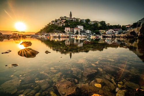 Bespiegeling van het dorp Vribnik op het eiland Krk bij zonsopgang