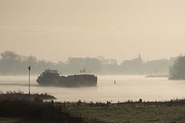 Binnenschiff auf einer nebligen IJssel in Wilsum