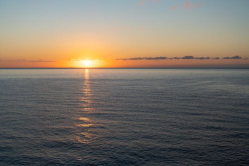 La lumière dorée du soleil se reflète dans la mer sur Adriana Mueller