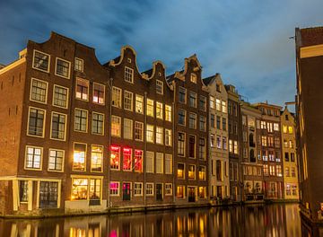 Amsterdamse grachten tijdens een winteravond met verlichte koopwaar