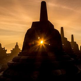 Borobudur at sunrise - sun through stupa by Chris Wiersma