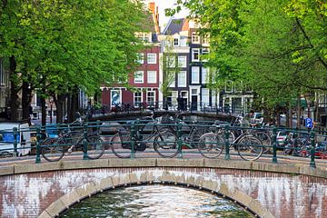 Fietsen op de brug in Amsterdam by Dennis van de Water