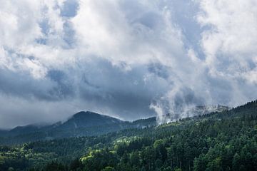 Nebelschwaden über Schwarzwaldbergen mit Sonne und Regenwolke von adventure-photos