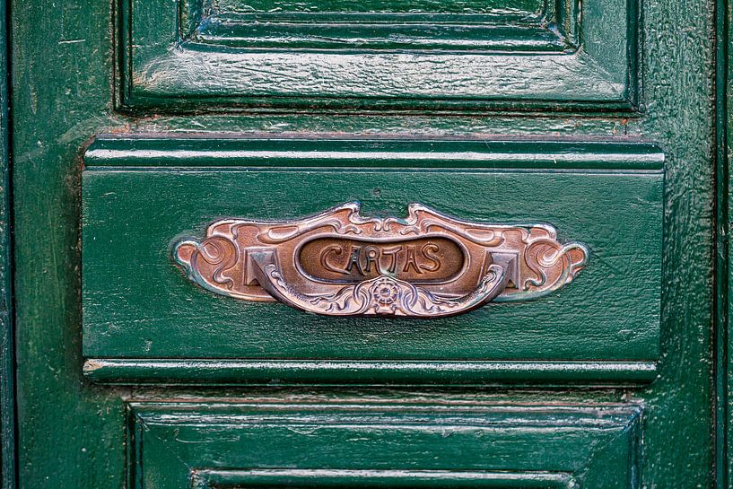Une boîte aux lettres espagnole typique sur une porte en bois verte par Jan van Dasler