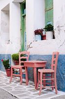 Chaises grecques dans une rue aux couleurs pastel à Samos
