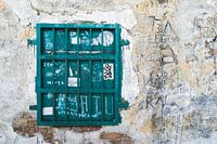 Verweerde muur met groen gesloten raam