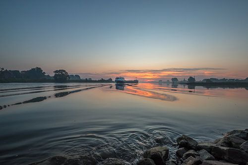 Binnenvaartschip op de Lek bij Ravenswaaij tijdens prachtige zonsopkomst