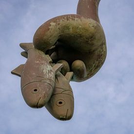 Een hand die vissen vasthoudt. Een kunstwerk van beelden aan zee scheveningen van Linda van der Meer