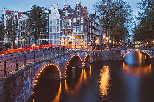 Beleuchtete Brücken über die Grachten von Amsterdam an einem Sommerabend