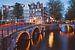Beleuchtete Brücken über die Grachten von Amsterdam an einem Sommerabend von Michiel Dros